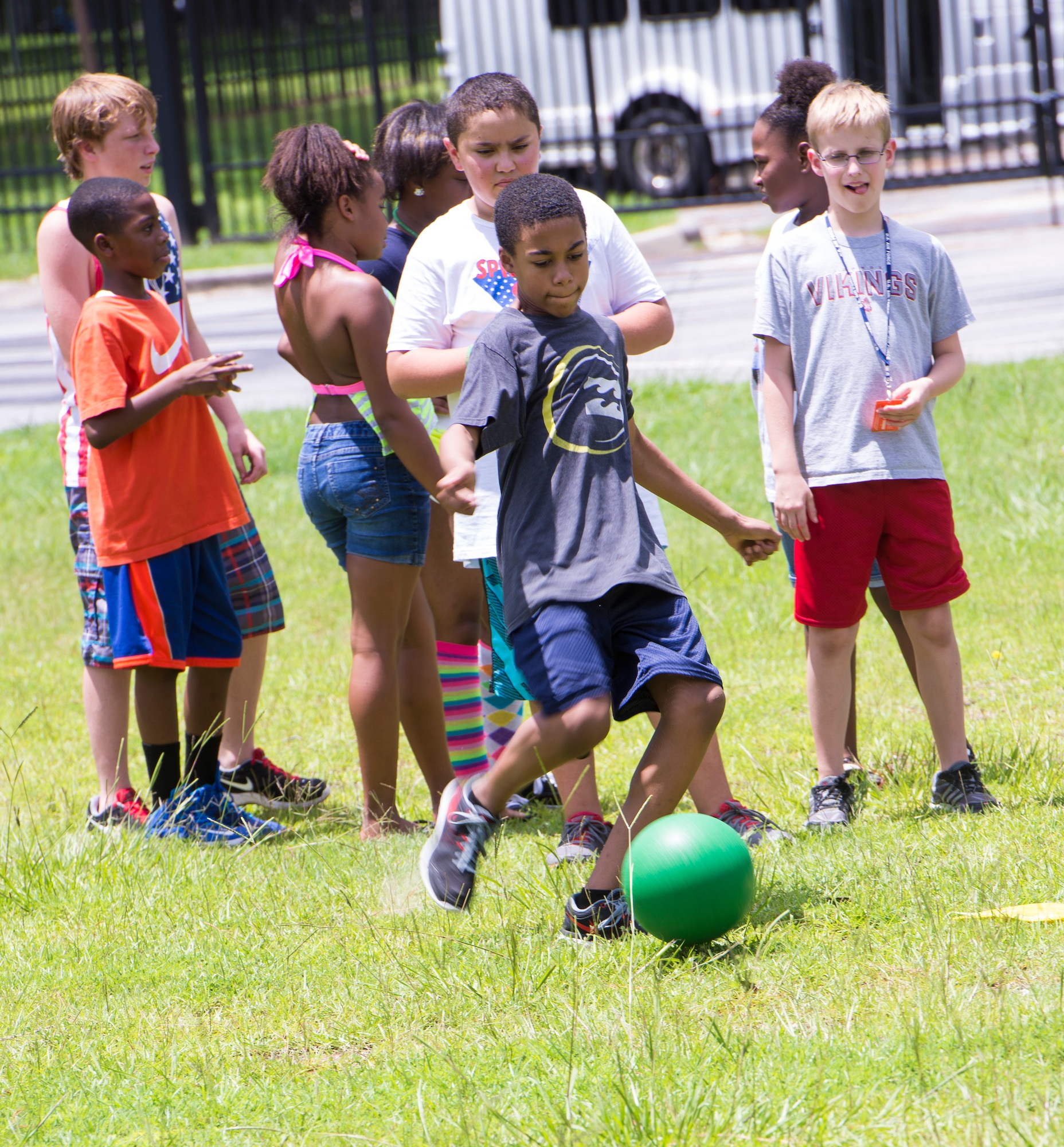 Deiondre Robinson, center, son of U.S. Air Force Master Sgt. Alton Robinson, 93d Air Ground Operations Wing, kicks the ball during a kickball game during the July Jamboree, July 6, 2015, at Moody Air Force Base, Ga. Approximately 50 kids participated in this year’s event. (U.S. Air Force photo by Airman Greg Nash/Released)