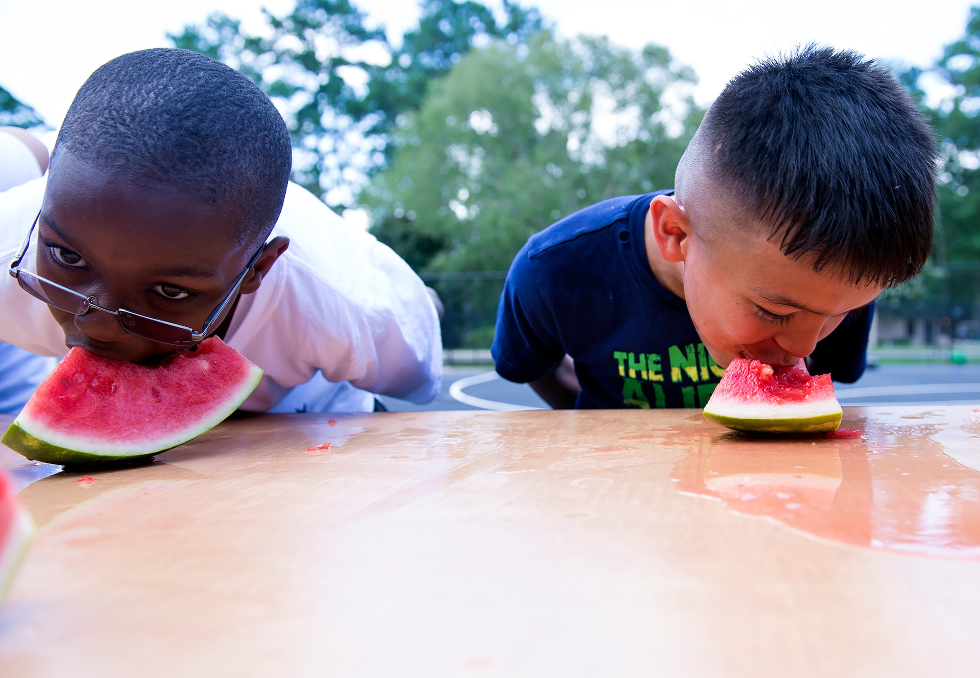 Omar Montgomery, left, son of Chelsea Montgomery, 23d Force Support Squadron, and Victor Garza III, son of U.S. Air Force Tech. Sgt. Victor Garza Jr., 723d Aircraft Maintenance Squadron, compete in a watermelon-eating contest during the July Jamboree, July 6, 2015, at Moody Air Force Base, Ga. The annual event also consisted of kickball games, water-balloon fights, three-legged races and a slip-and-slide bounce house. (U.S. Air Force photo by Airman Greg Nash/Released)