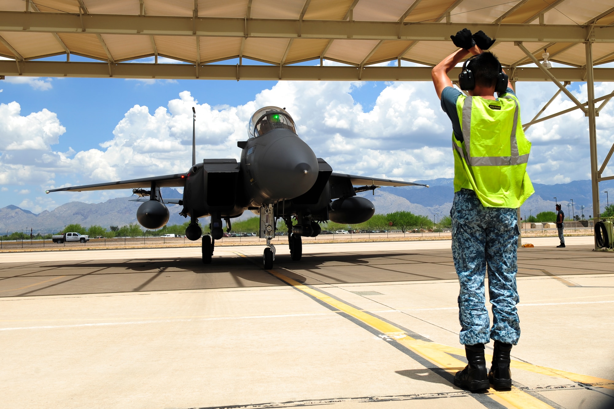 Republic of Singapore Air Force Assistant Expert Luo Youyang, 428th Fighter Squadron crew chief, taxis an F-15SG fighter jet from the 428th Fighter Squadron located at Mountain Home Air Force Base, Idaho, under a sunshade at Davis-Monthan Air Force Base, Ariz., July 7, 2015. The 428th FS was established by the Peace Carvin V program, a partnership between the U.S. Air Force and Republic of Singapore Air Force to training the RSAF pilots, weapons systems operators, ground control intercept officers, and maintainers to be able to operate their fleet. (U.S. Air Force photo by Airman 1st Class Chris Drzazgowski/Released)