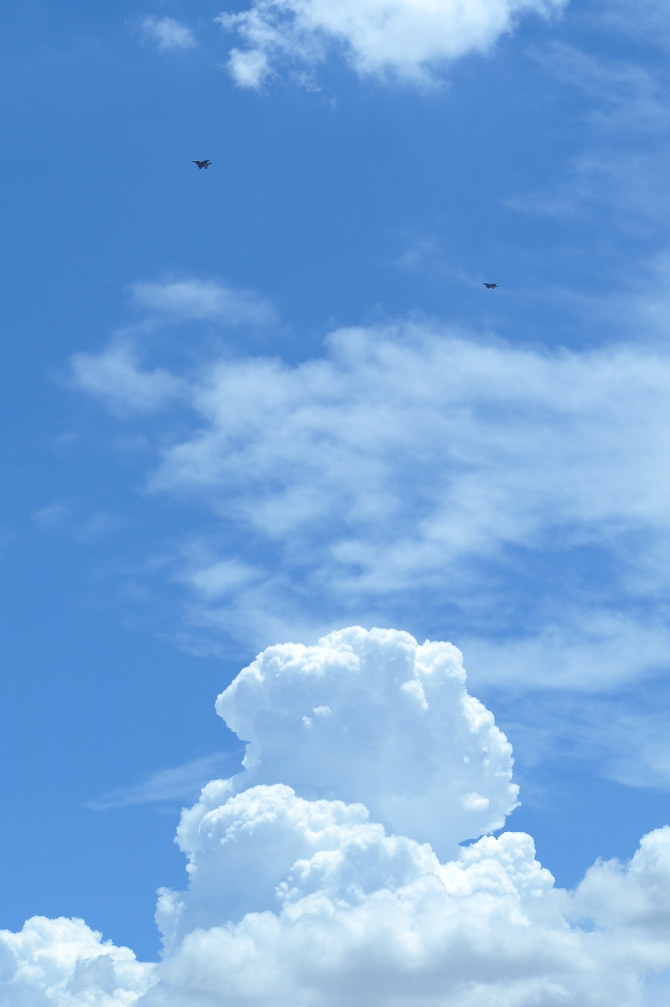 Two F-15SG fighter jets from the 428th Fighter Squadron at Mountain Home Air Force Base, Idaho, fly above a storm cloud at Davis-Monthan Air Force Base, Ariz., July 7, 2015. The 428th FS was established by the Peace Carvin V program, a partnership between the U.S. Air Force and Republic of Singapore Air Force to training the RSAF pilots, weapons systems operators, ground control intercept officers, and maintainers to be able to operate their fleet. (U.S. Air Force photo by Airman 1st Class Chris Drzazgowski/Released)