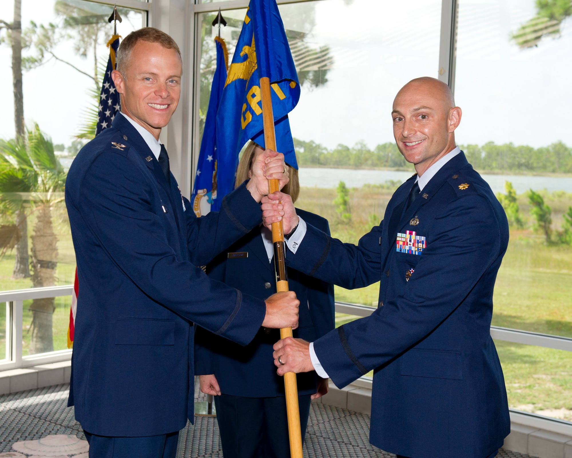 Colonel Derek C. France, the 325th Fighter Wing commander, passes the 325th Comptroller Squadron guidon to Maj. Jared Mitchell, 325th CPTS commander, during a change of command ceremony June 30. Mitchell replaces Maj. Timothy Fast who will go on to serve as the 82nd Comptroller Squadron commander at Sheppard AFB, Texas. (U.S. Air Force photo by Senior Airman Alex Echols/Released)