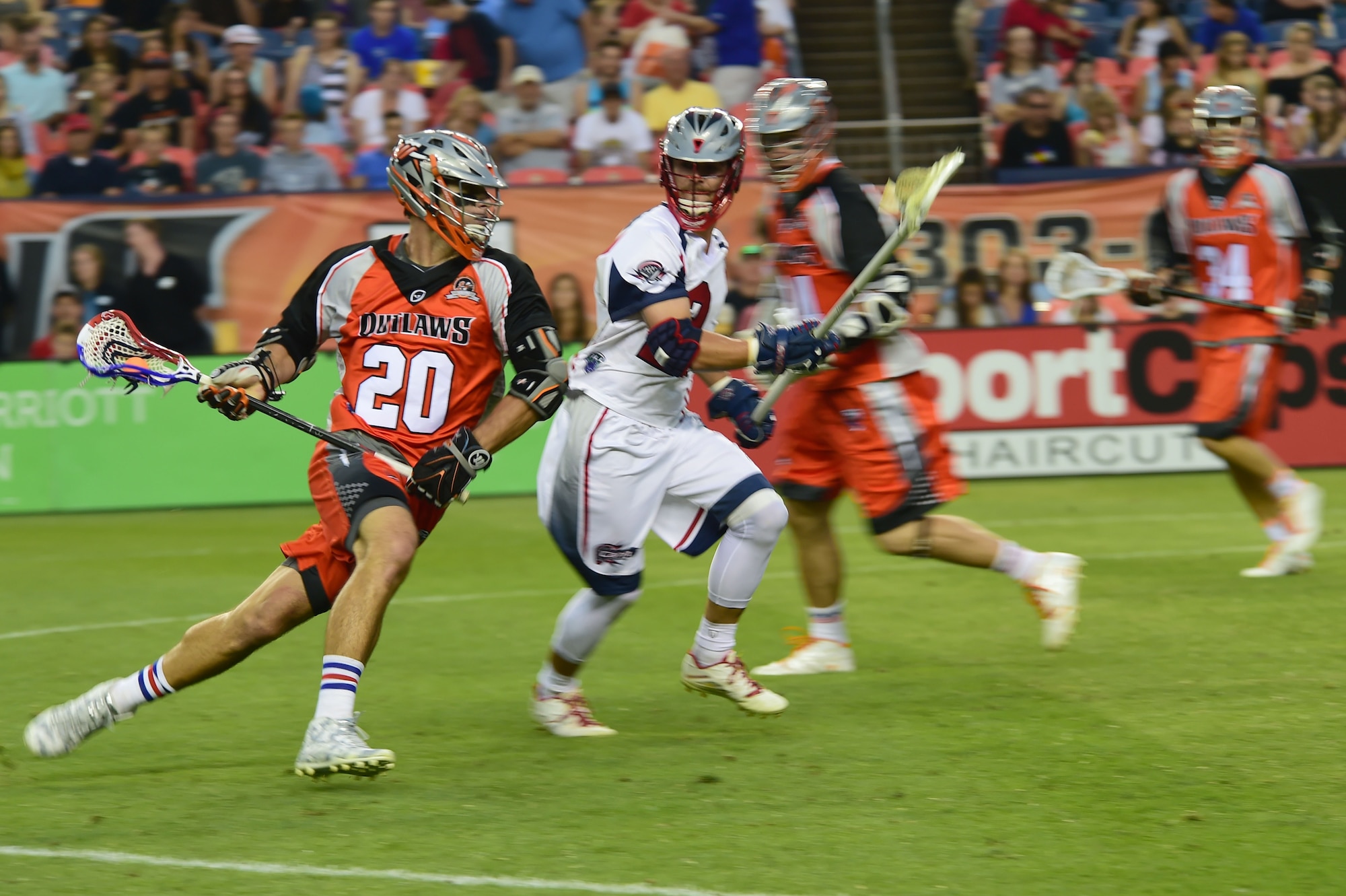 Jeremy Sieverts, midfielder for the Denver Outlaws, dodges a defender from the Boston Cannons July 4, 2015, at Sports Authority Field at Mile High Stadium in Denver. The Outlaws hosted the Cannons in a Major League Lacrosse game which honored military members on Independence Day. (U.S. Air Force photo by Airman 1st Class Luke W. Nowakowski/Released)