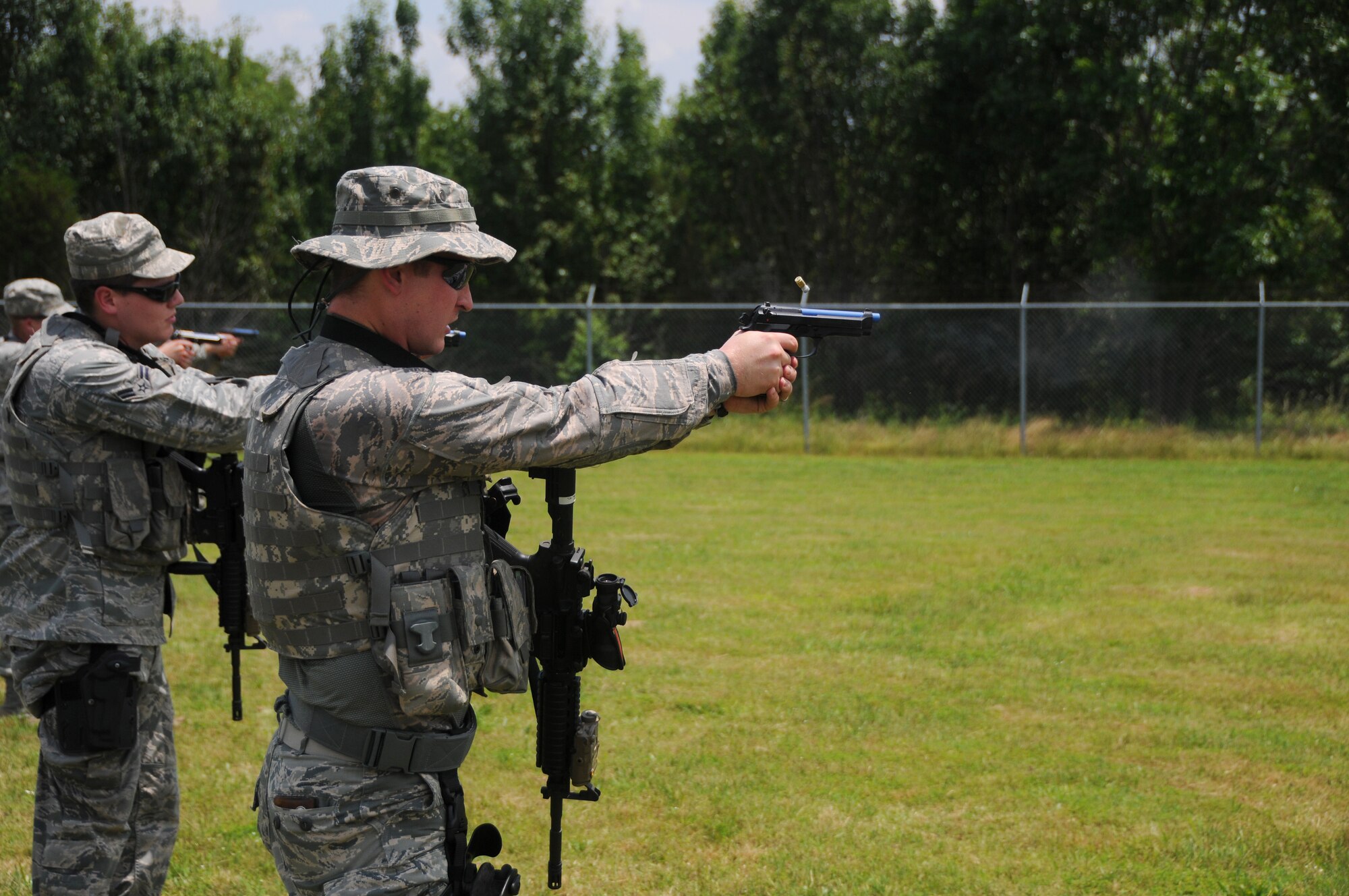 Airman 1st Class Ronald Adkins, 188th Security Forces specialist, and Airman 1st Class Corey Smith, 188th Security Forces advanced designated marksman, sharpen their skills with the M9 pistol during shoot, move and communicate drills June 9, 2015, at Ebbing Air National Guard Base, Fort Smith, Ark. This weapon sustainment training is an annual requirement for Security Forces members aimed at increasing weapon deployment abilities of the team and individual. (U.S. Air National Guard photo by Senior Airman Cody Martin/Released)