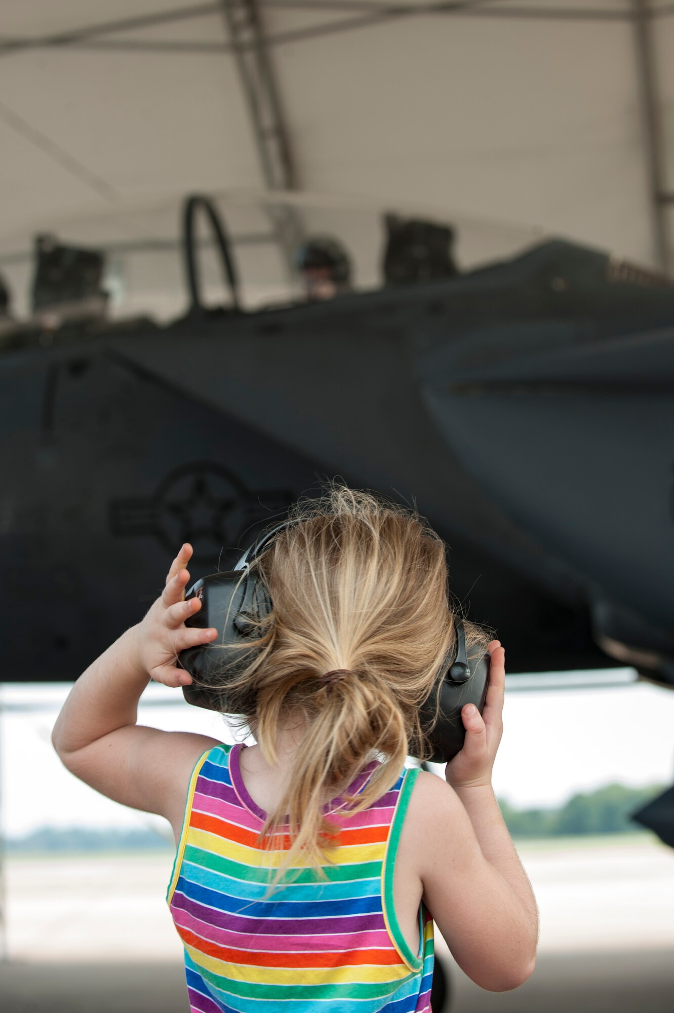 The child of Capt. Brandon Glass, 4th Component Maintenance Squadron component maintenance operations officer, waives to her mom during a spouse orientation, July 1, 2015, at Seymour Johnson Air Force Base, North Carolina. The orientation program allowed service members’ families to see the work they do on a daily basis. (U.S. Air Force photo/Airman Shawna L. Keyes)