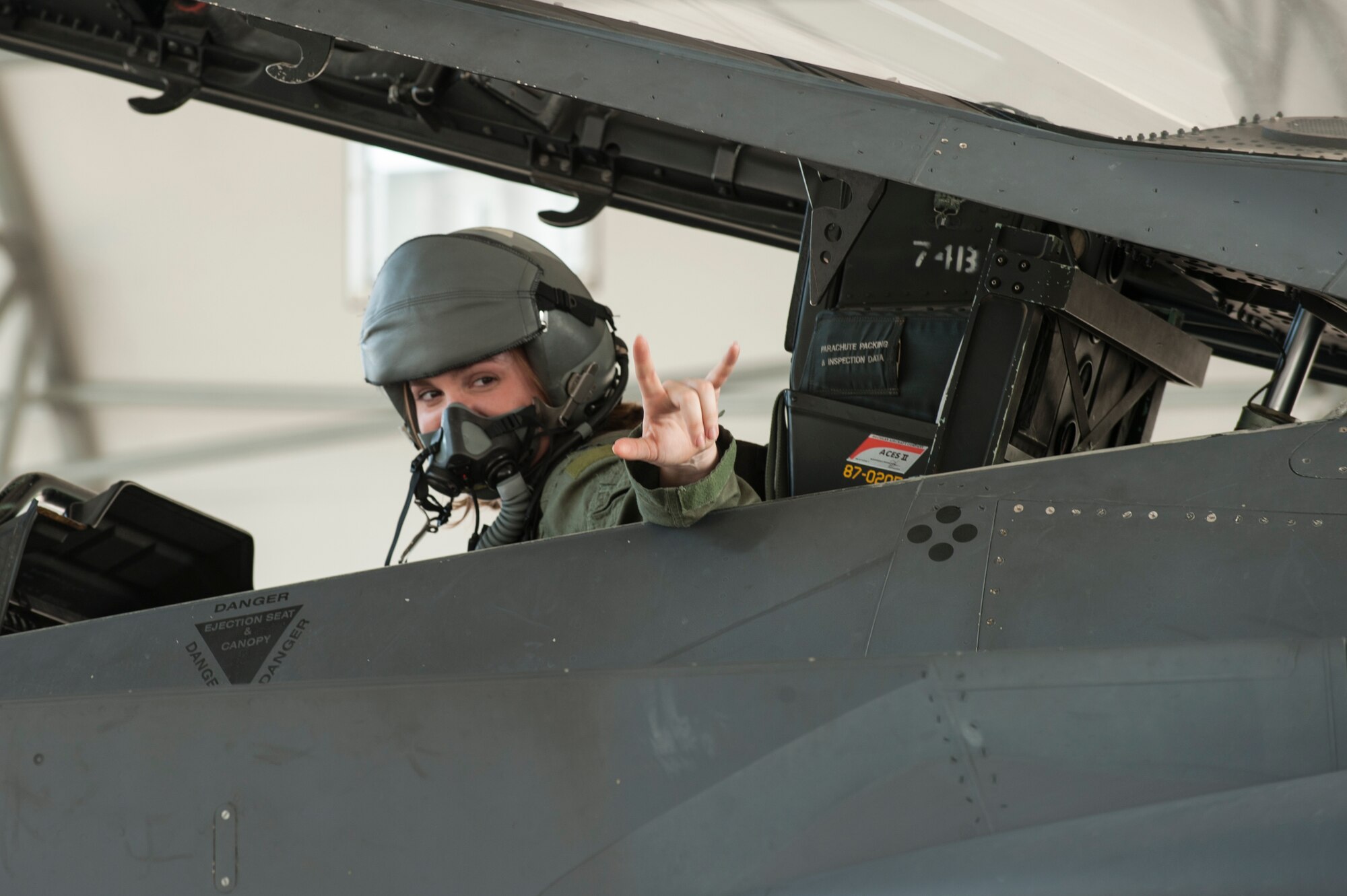 Ryan Glass, wife of Capt. Brandon Glass, 4th Component Maintenance Squadron component maintenance operations officer, signals to her child from an F-15E Strike Eagle during a spouse orientation, July 1, 2015, at Seymour Johnson Air Force Base, North Carolina. Glass and other spouses were put in the backseat of an F-15E Strike Eagle to demonstrate the capabilities of the aircraft. (U.S. Air Force photo/Airman Shawna L. Keyes)
