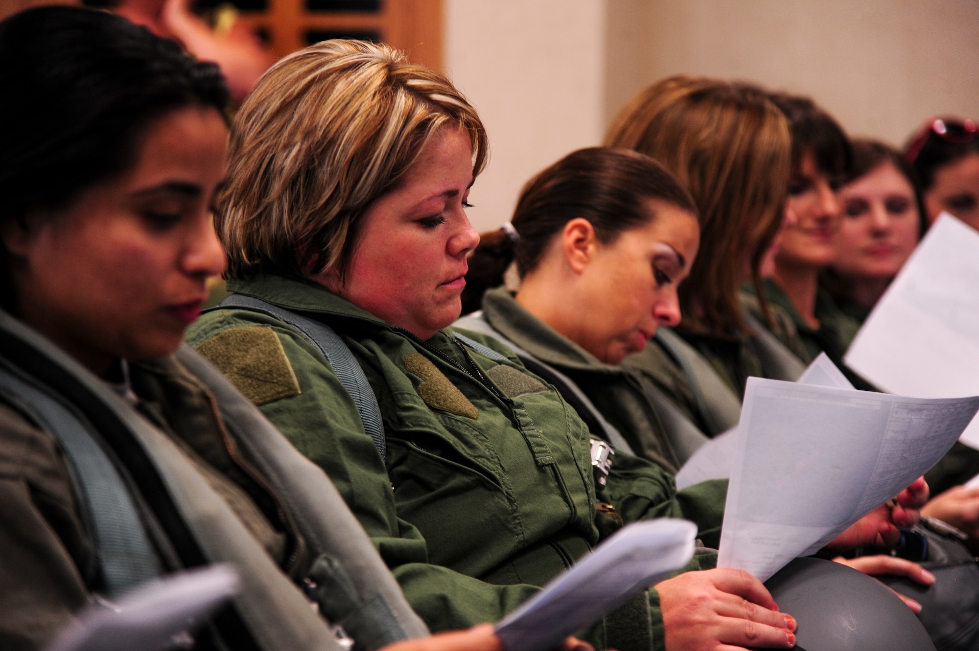 4th Maintenance and 4th Operations Groups spouses listen to and follow along with a pre-flight brief as part of a spouse orientation, July 1, 2015, at Seymour Johnson Air Force Base, North Carolina. During the brief, the spouses identified their call signs, discussed the planned mission, and did a quick rehearsal of radio chat responsibilities. (U.S. Air Force photo/Senior Airman Brittain Crolley)