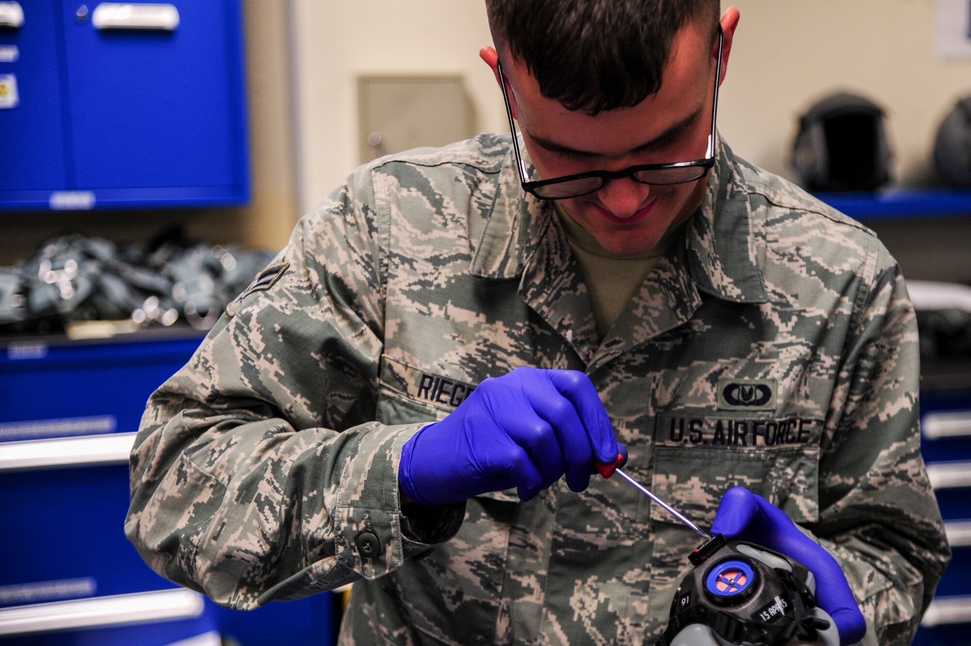 Airman 1st Class Robert Riegel, 4th Operations Support Squadron aircrew flight equipment technician, adjusts a mask breathing unit as part of a spouse orientation, July 1, 2015, at Seymour Johnson Air Force Base, North Carolina. The spouses were fitted for full life support equipment to prepare them for full immersion into the backseat of the F-15E Strike Eagle. (U.S. Air Force photo/Senior Airman Brittain Crolley)