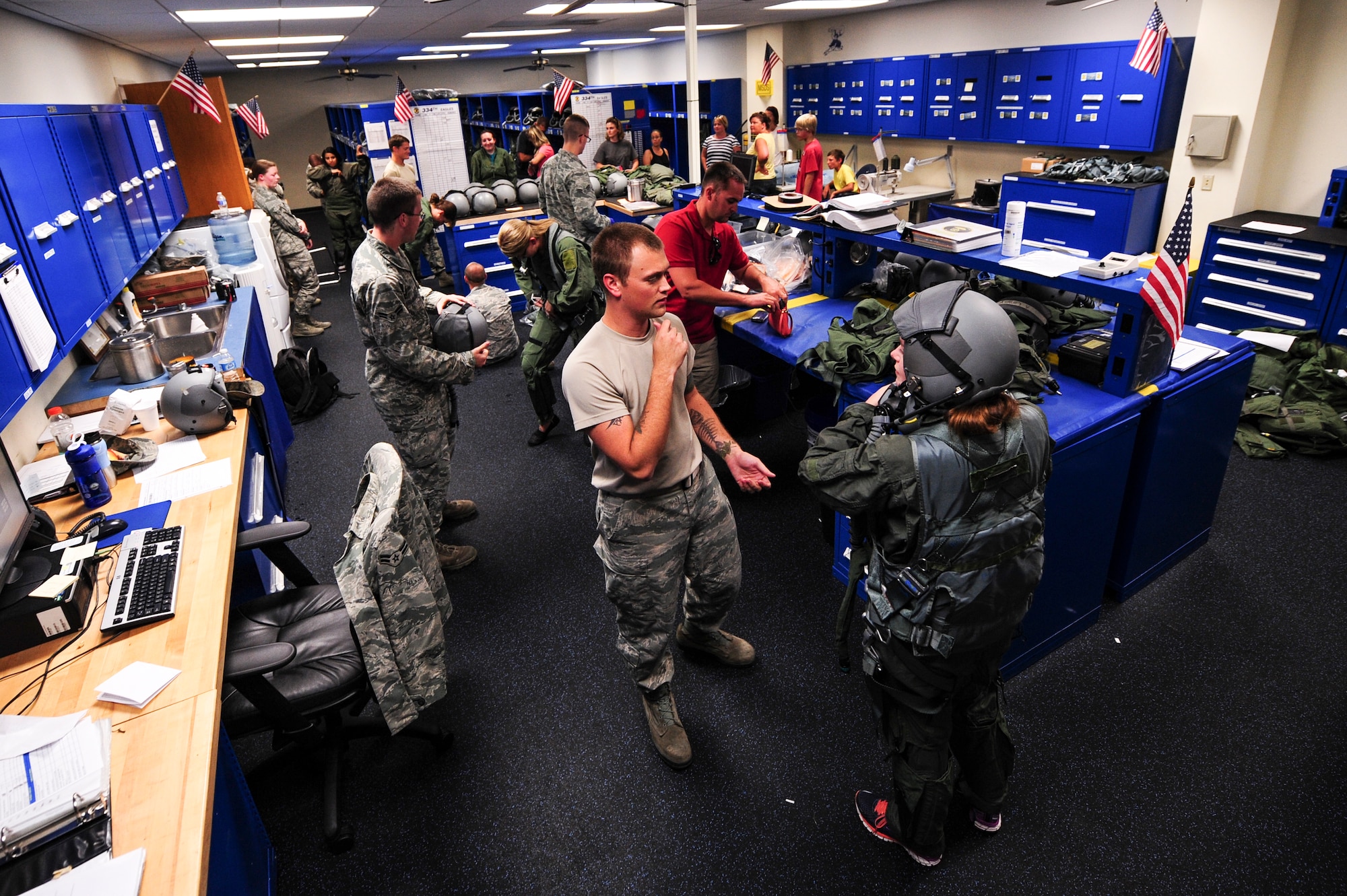 Airmen from the 4th Operations Support Squadron aircrew flight equipment fit spouses with life support equipment and flight suits as part of a spouse orientation, July 1, 2015, at Seymour Johnson Air Force Base, North Carolina. Spouses from the 4th Maintenance and 4th Operations Groups were given the opportunity to integrate with the F-15E Strike Eagles their spouses fly and maintain on a regular basis. (U.S. Air Force photo/Senior Airman Brittain Crolley)