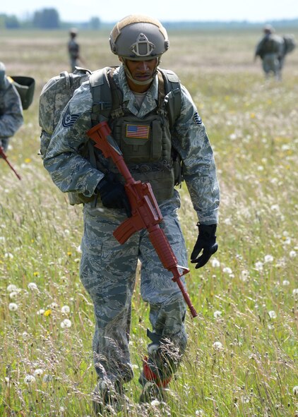 An Airman assigned to the 435th Security Forces Squadron, Ramstein Air Base, Germany, heads to his rally point after parachuting from a C-130J Hercules aircraft during an austere landing exercise in Nurmsi, Estonia during Saber Strike 15, June 11, 2015. Members of the 435th Contingency Response Group trained to secure and assess an area for suitability as a landing strip for follow on aircraft. (Air National Guard photo by Tech. Sgt. Christopher Schepers)