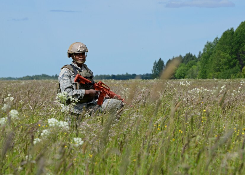 An Airman assigned to the 435th Security Forces Squadron, Ramstein Air Base, Germany, conducts security operations after parachuting from a C-130J Hercules aircraft during an austere landing exercise in Nurmsi, Estonia during Saber Strike 15, June 11, 2015. Members of the 435th Contingency Response Group trained to secure and assess an area for suitability as a landing strip for follow on aircraft. (Air National Guard photo by Tech. Sgt. Christopher Schepers)