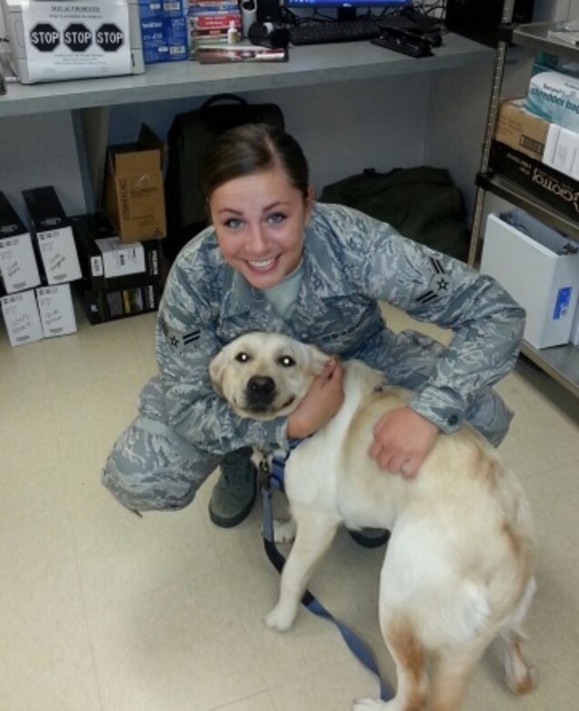 U.S. Air Force Airman 1st Class Haley Benson, 633rd Medical Operations Squadron behavioral health technician takes a photo with Lily, a therapy dog, at the 633rd Medical Operations Squadron Behavioral Health clinic at Langley Air Force Base, Va., July 2, 2014. Benson, along with other mental health technicians works with Lily as a way to boost morale in the intelligence squadrons on base. (Courtesy photo)