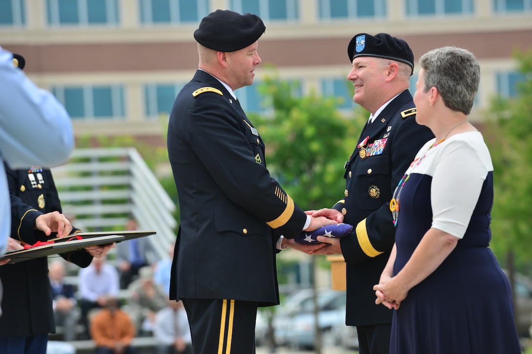 U.S. Army Gen. David E. Perkins, U.S. Army Training and Doctrine Command commander, hands Maj. Gen. Ross E. Ridge, Center for Initial Military Training outgoing commander, a retirement flag during the retirement portion of the CIMT change of command ceremony at Fort Eustis, Va., July 2, 2015. Ridge retired after 35 years of service, two of which were served commanding CIMT. (U.S. Air Force photo by Staff Sgt. Natasha Stannard/released)