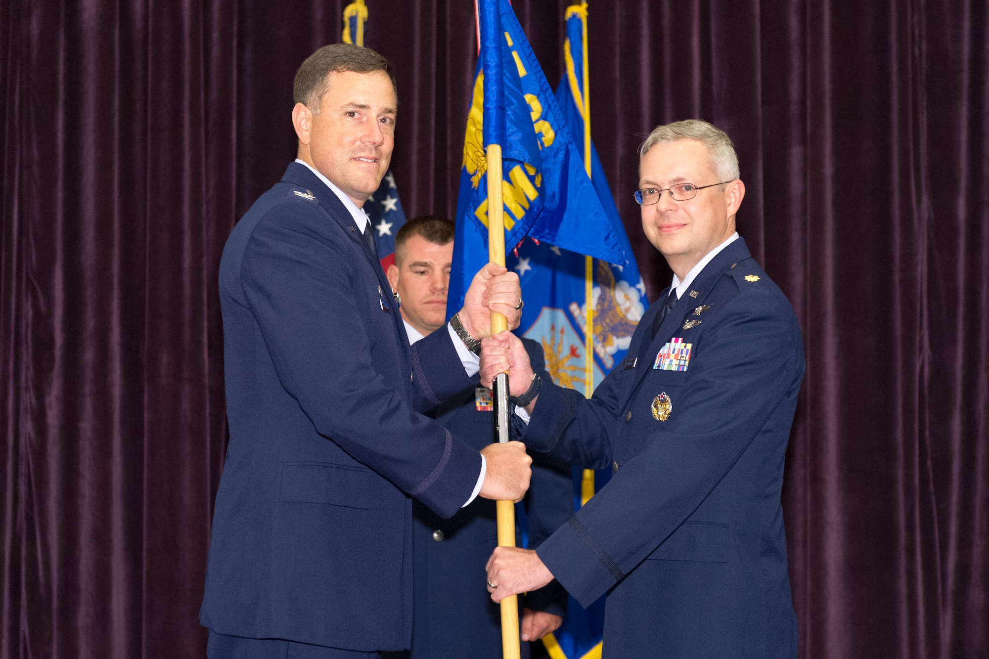 Col. Thomas Falzarano, 45th Operations Group commander, left, presents Maj. Elwood Waddell, 45th Range Management Squadron commander, with the 45th RMS guidon during a change of command ceremony July 1, 2015, at Patrick Air Force Base, Fla. Changes of command are a military tradition representing the transfer of responsibilities from the presiding officials to the upcoming official. (U.S. Air Force photo/Cory Long) (Released)