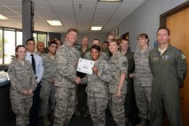 Airman 1st Class Kera Bowen, center, 85th Flying Training Squadron aviation resource management apprentice, poses with Col. Thomas Shank, left, 47th Flying Training Wing commander, and Chief Master Sgt. Teresa Clapper, 47th FTW command chief, after accepting the XLer of the Week award, here, July 1, 2015. The XLer is a weekly award chosen by wing leadership and is presented to those who consistently make outstanding contributions to their unit and Laughlin. (U.S. Air Force photo by Airman 1st Class Brandon May)