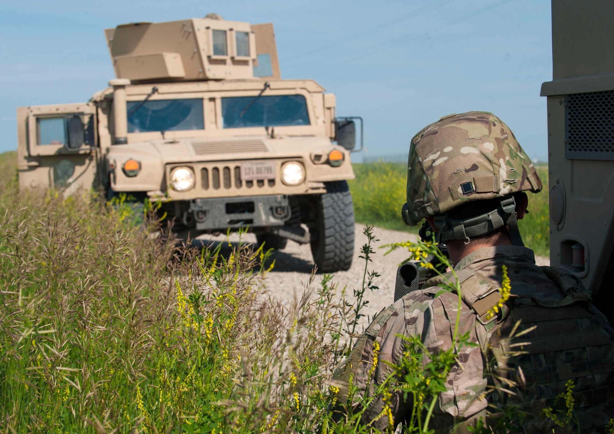 A 91st Missile Wing Security Forces Group member guards a humvee during an exercise area near Donnybrook, N.D., June 29, 2015. Three Humvees and four Bearcats were used to respond during the simulated recapture of a launch facility. (U.S. Air Force photo/Senior Airman Stephanie Morris)