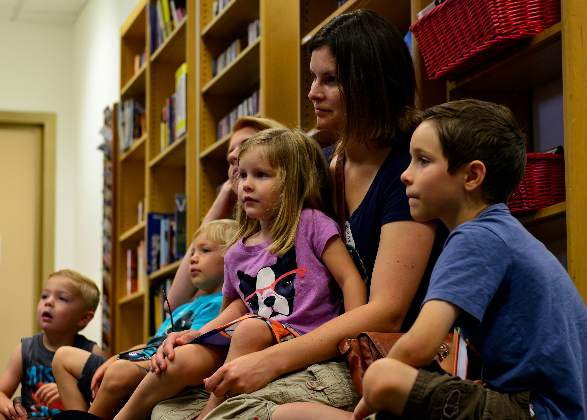 Parents and their children listen to sing-a-long stories in the library, July 7, 2015, at Aviano Air Base, Italy. The library hosted story time with a theme of “In a Band,” that involved reading, singing, and arts and crafts. (U.S. Air Force photo by Airman 1st Class Cary Smith/Released)
