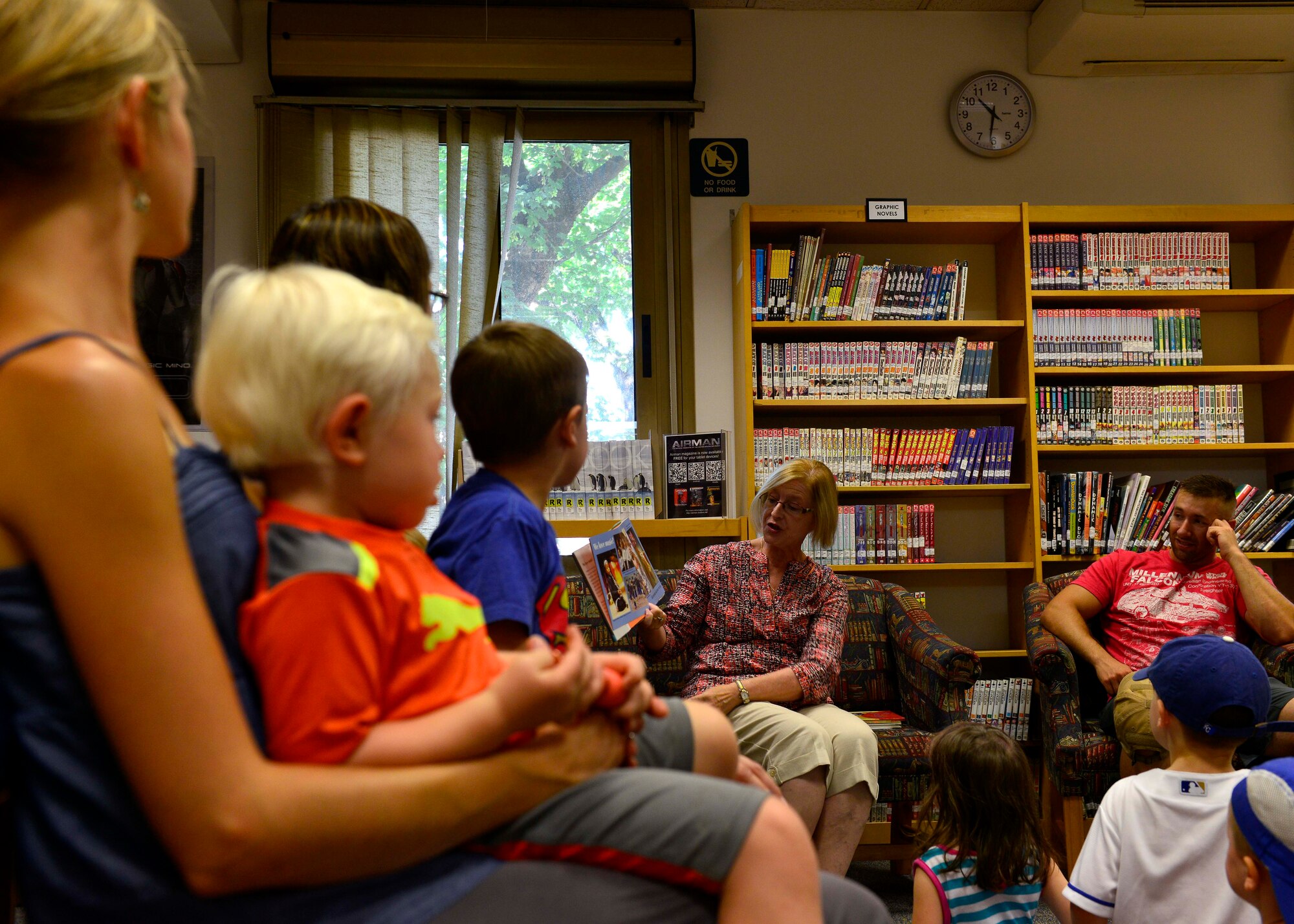 Parents and their children listen to Sharon Amann, 31st Force Support Squadron librarian supervisor, read during story time, July 7, 2015, at Aviano Air Base, Italy. After children participated in a sing-a-long, they danced and crafted their own maracas. (U.S. Air Force photo by Airman 1st Class Cary Smith/Released)