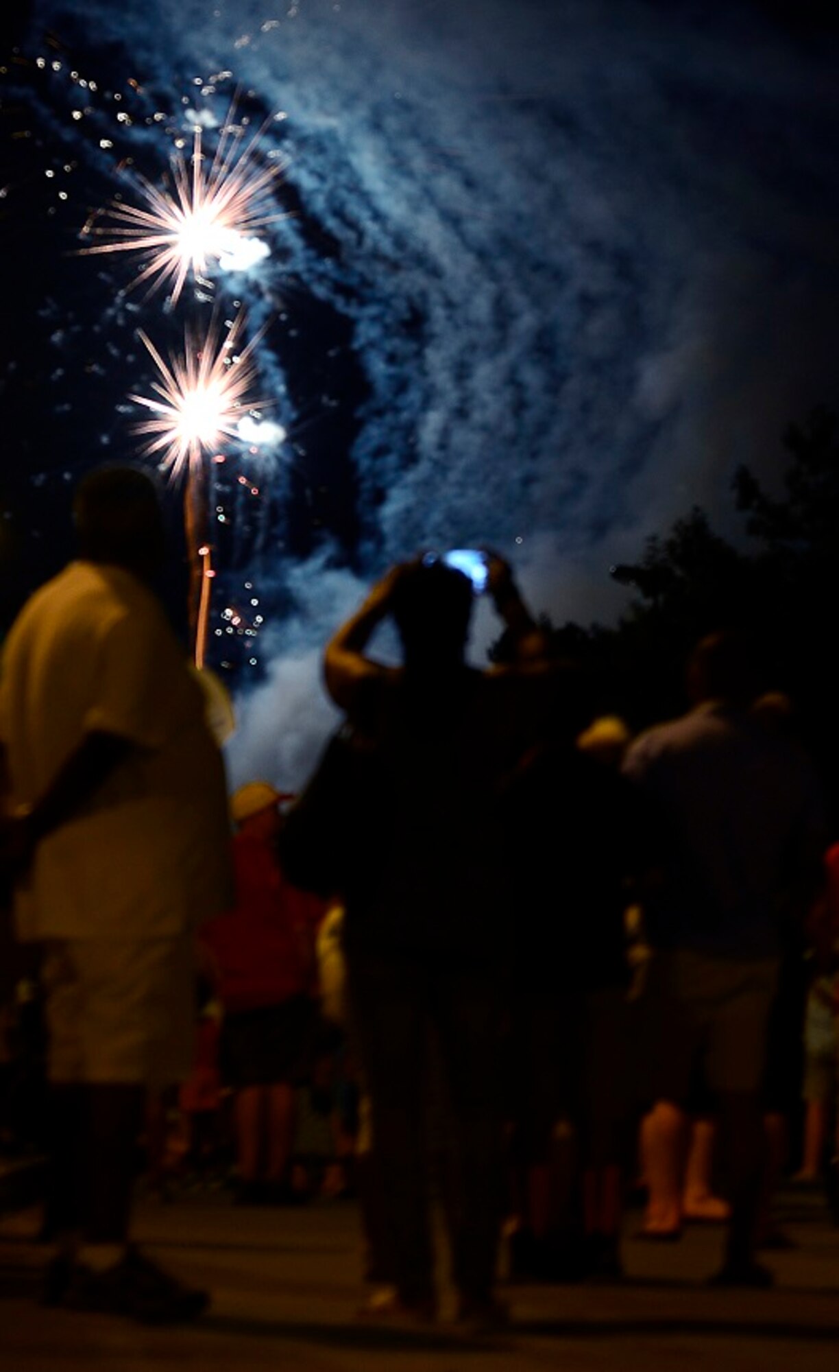 Members of the Kaiserslautern Military Community watch a firework show during this year’s Freedom Fest July 4, 2015, at Ramstein Air Base, Germany. The fair was a two-day event held in celebration of the United States’ Independence Day. Attendees were able to enjoy rides, food, games and live music. (U.S. Air Force photo/Airman 1st Class Tryphena Mayhugh)