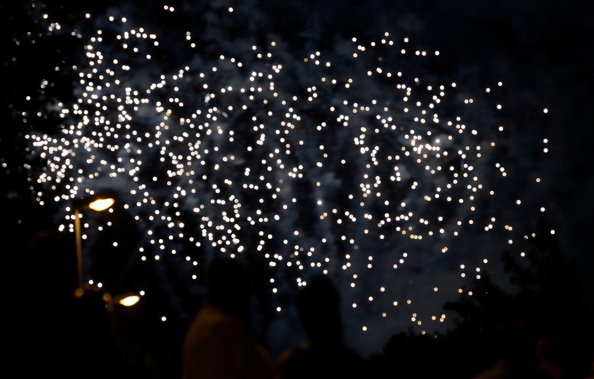Patrons of this year’s Freedom Fest watch a firework show July 4, 2015, at Ramstein Air Base, Germany. The fair was a two-day event held in celebration of the United States’ Independence Day. Attendees were able to enjoy rides, food, games and live music. (U.S. Air Force photo/Airman 1st Class Tryphena Mayhugh)