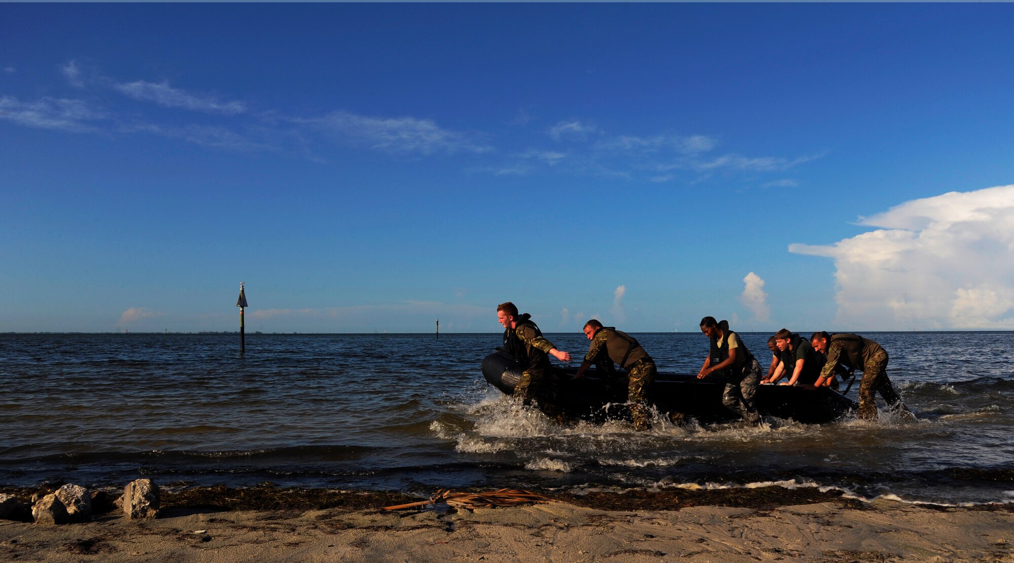 Members from the Joint Communications Support Element and British army 258th Signal Squadron pull their team’s boat to the shore at MacDill Air Force Base, Fla., June 24, 2015. The team bonding event challenged their communication and leadership skills. (U.S. Air Force photo by Airman 1st Class Danielle Conde/Released)