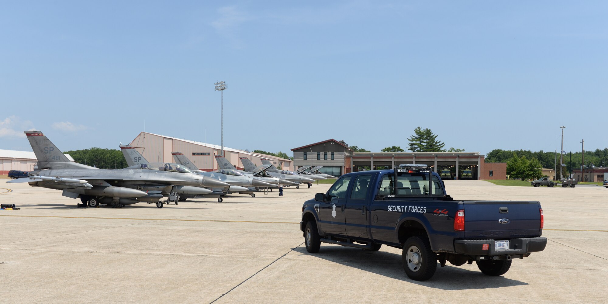 Members of the 157th Security Forces Squadron watch as pilots from the 480th Fighter Squadron, 52nd Fighter Wing, Spangdahlem Air Base, Germany taxi their aircraft at Pease Air National Guard Base, N.H., on July 6, 2015.  A contingent of the Spangdahlem-based aircraft landed at Pease while in transit to a training exercise in the United States. The 52 FW supports the supreme allied commander Europe with mission-ready personnel and systems providing expeditionary air power for suppression of enemy air defenses, close air support, air interdiction, counter air, air strike control, strategic attack, combat search and rescue, and theater airspace control. The wing also supports contingencies and operations other than war as required. U.S. Air National Guard photo by Staff Sgt. Curtis J. Lenz/RELEASED)