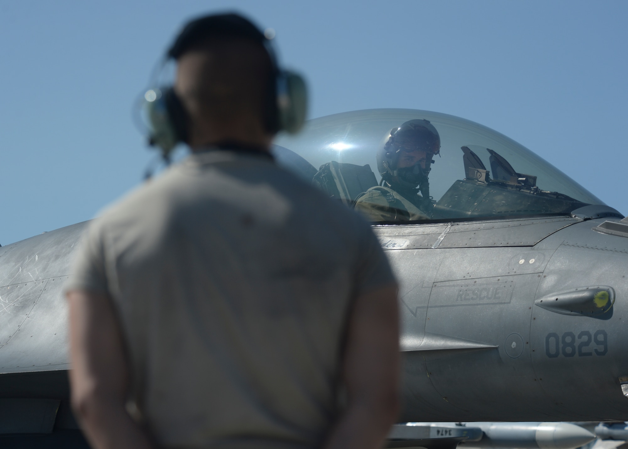 A U.S. Air Force crew chief assigned to the 52nd Aircraft Maintenance Squadron stands by as an F-16 Fighting Falcon fighter aircraft pilot assigned to the 480th Fighter Squadron prepares for taxiing from the flightline at Spangdahlem Air Base, Germany, July 6, 2015. The aircraft will participate in Red Flag, an exercise which includes both US and allied nations' combat air forces. (U.S. Air Force photo by Staff Sgt. Joe W. McFadden/Released)
