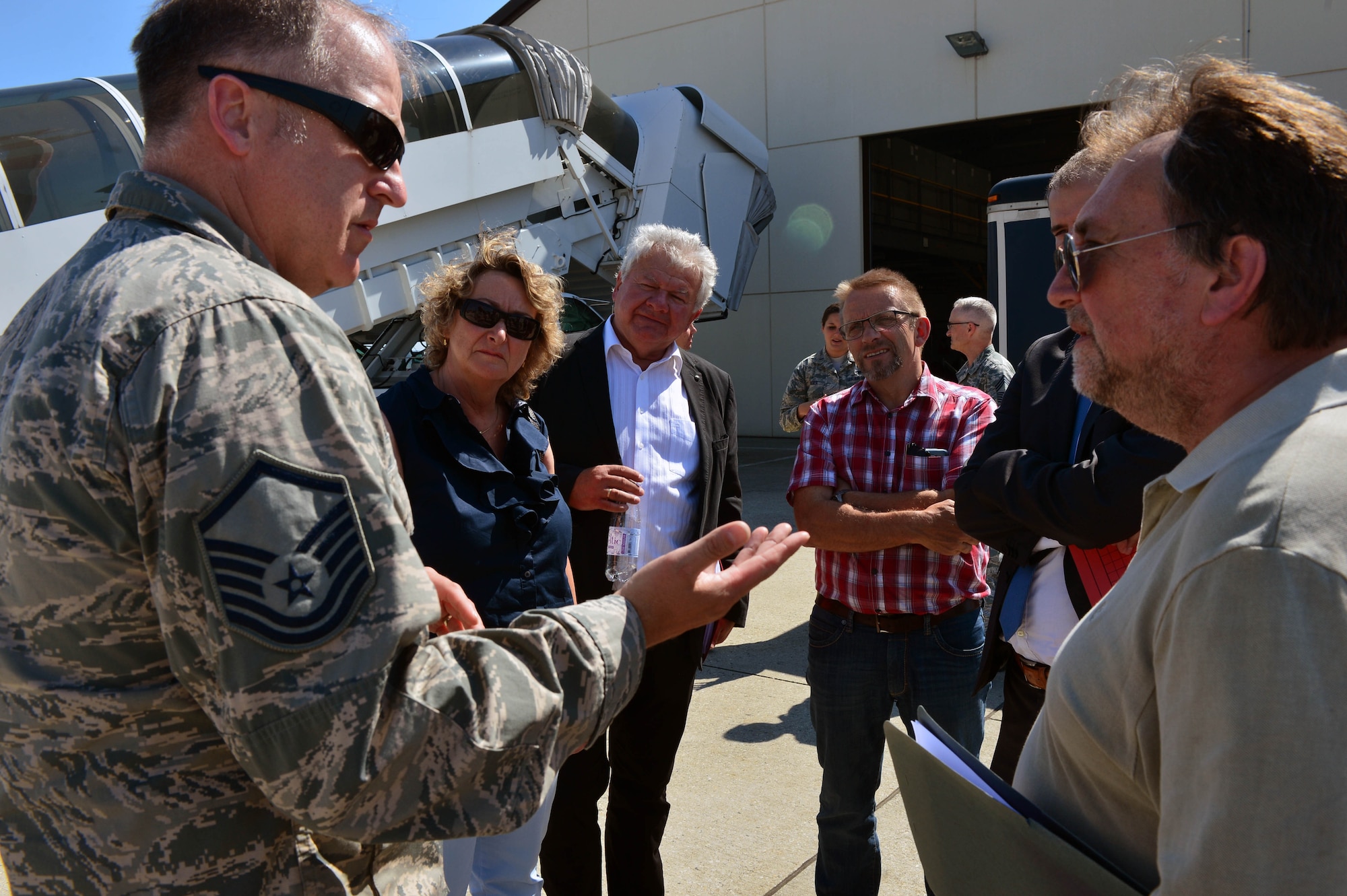 U.S. Air Force Master Sgt. David Haston, 726th Air Mobility Squadron superintendent of passenger services, talks to local German leaders during a base orientation tour at Spangdahlem Air Base, Germany, July 1, 2015. The 726th AMS is a tenant unit at Spangdahlem Air Base that helps provide air transportation, maintenance and support to American and allied forces. (U.S. Air Force photo by 2nd Lt Meredith Mulvihill/Released)
