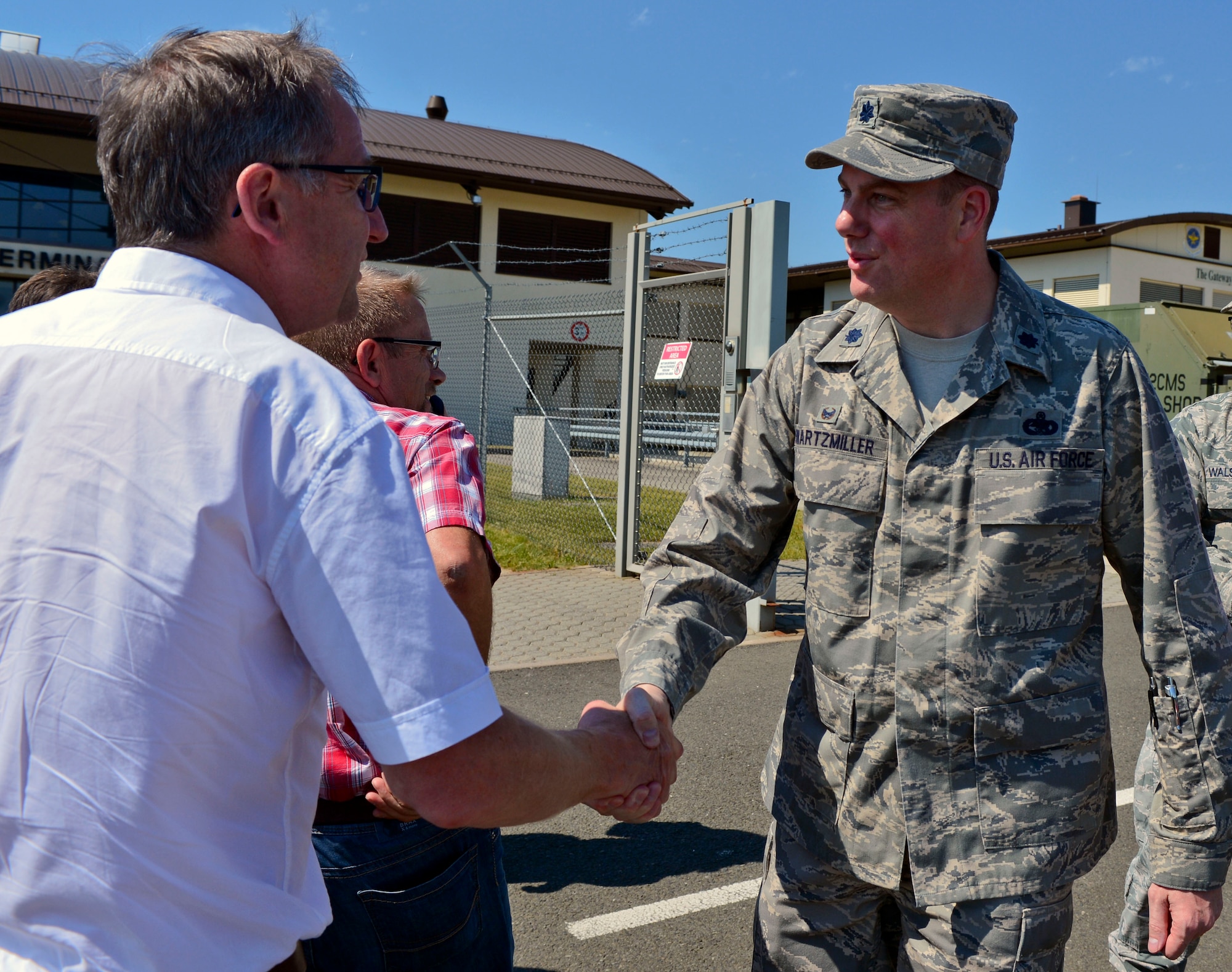 U.S. Air Force Lt. Col. Justin Swartzmiller, 726th Air Mobility Squadron commander, shakes hands with Ludwig Schmitz, mayor of Arenrath, Germany, during a base orientation tour at Spangdahlem Air Base, Germany, July 1, 2015. The community leaders visited the 726th AMS as part of their tour coordinated by the 52nd Fighter Wing Community Relations office. (U.S. Air Force photo by 2nd Lt Meredith Mulvihill/Released)