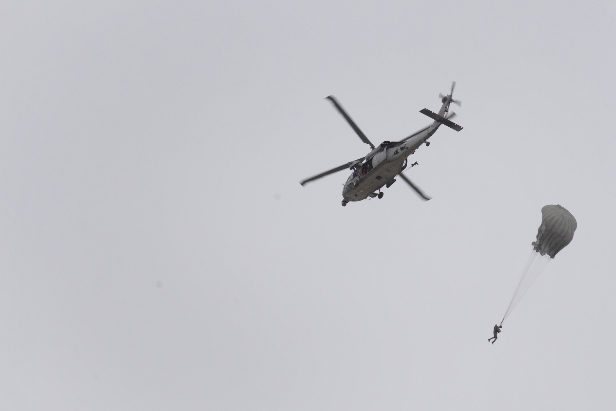 A 736th Security Forces Squadron paratrooper jumps from a MH-60 Sierra, assigned to Helicopter Sea Combat Squadron 25, July 3, 2015, at Andersen Air Force Base, Guam. Airmen of the 736th SFS perform static line parachute operations quarterly to maintain proficiency. (U.S. Air Force photo by Senior Airman Katrina M. Brisbin/Released)