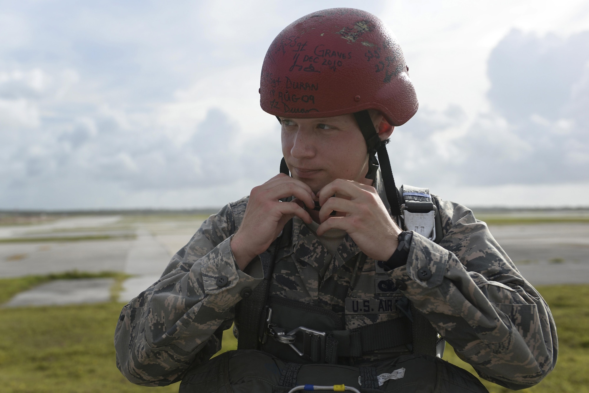 Capt. Justin Bateman, 736th Security Forces Squadron director of operations, dons a red helmet prior to a static line parachute operation July 3, 2015, at Andersen Air Force Base, Guam. The red helmet identifies members who are performing their first jump after U.S. Army Basic Airborne School. Per tradition, Bateman signed the helmet after completing his jump. (U.S. Air Force photo by Senior Airman Katrina M. Brisbin/Released)