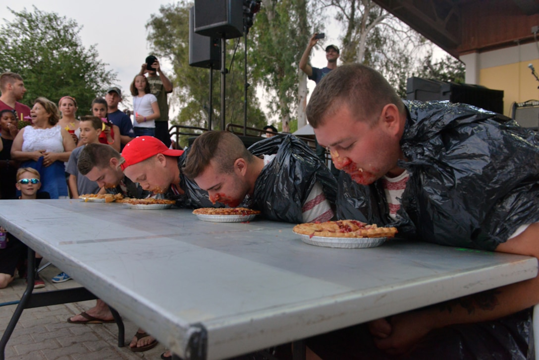 Four Airmen from Team Incirlik compete in a pie eating contest during a 4th of July Festival July 4, 2015, at Incirlik Air Base, Turkey.  The event also included a performance by special guest Alaina Blair, American singer and Armed Forces Entertainment performer and a fireworks display. (U.S. Air Force photo by Senior Airman Michael Battles/Released)
