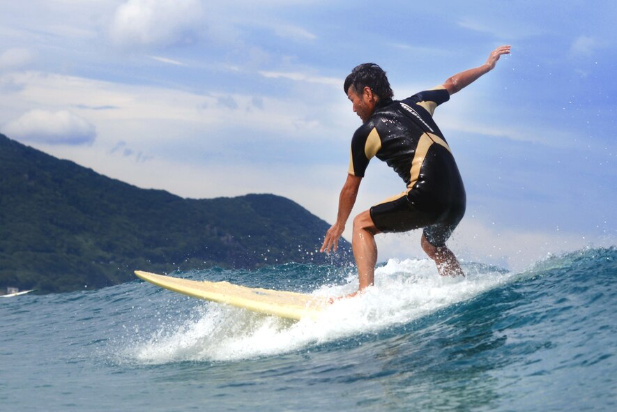 A Japanese local rides the waves of Tadato Beach in Shimoda, Japan, June 27, 2015. As part of the Yokota Air Base's Single Airman Program, Airmen had the opportunity to learn to surf and strengthen their relationships. (U.S. Air Force photo by Airman 1st Class Delano Scott/Released)