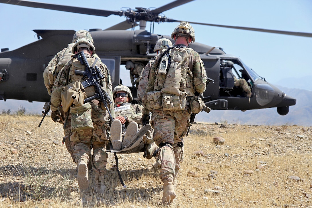 U.S. soldiers carry a simulated casualty to a UH-60 Black Hawk medevac helicopter during a live-fire exercise on Tactical Base Gamberi, Afghanistan, July 3, 2015.