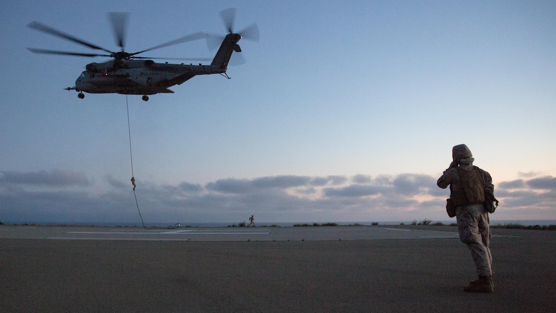 Marines from Golf Company, Battalion Landing Team 2nd Battalion, 1st Marine Regiment fast rope from a CH-53E Super Stallion on Marine Corps Base Camp Pendleton, California, July 2. The helicopter pilots maintained a steady hover while Marines fast-roped to the ground below.