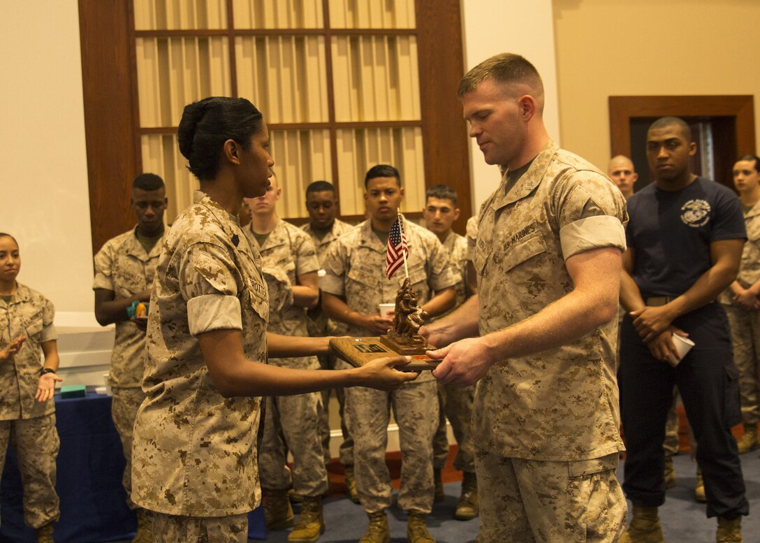 Capt. John Ed Auer revieves a commemorative plaque after the Change of Command ceremony for  Headquarters and Service Company, Marine Barracks Washington, D.C., inside Crawford Hall, July 8, 2015. (U.S. Marine Corps photo by Cpl. Chi Nguyen/Released)