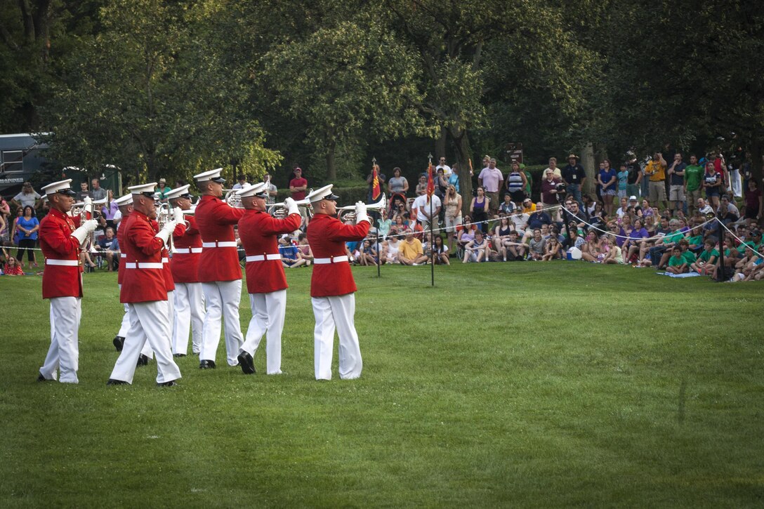 U.S. Marines with the U.S. Marine Corps Drum and Bugle Corps perform during a Sunset Parade at the Marine Corps War Memorial, Arlington Va., July 07, 2015. Retired U.S. Marine Corps Chief Warrant Officer 4 Hershel “Woody” Williams was the guest of honor for the parade, and Lt. Gen. Ronald L. Bailey was the hosting official. Since September 1956, marching and musical units from Marine Barracks Washington, D.C., have been paying tribute to those whose “uncommon valor was a common virtue” by presenting sunset parades in the shadow of the 32-foot high figures of the United States Marine Corps War Memorial. (U.S. Marine Corps photo by Lance Cpl. Alex A. Quiles/Released)
