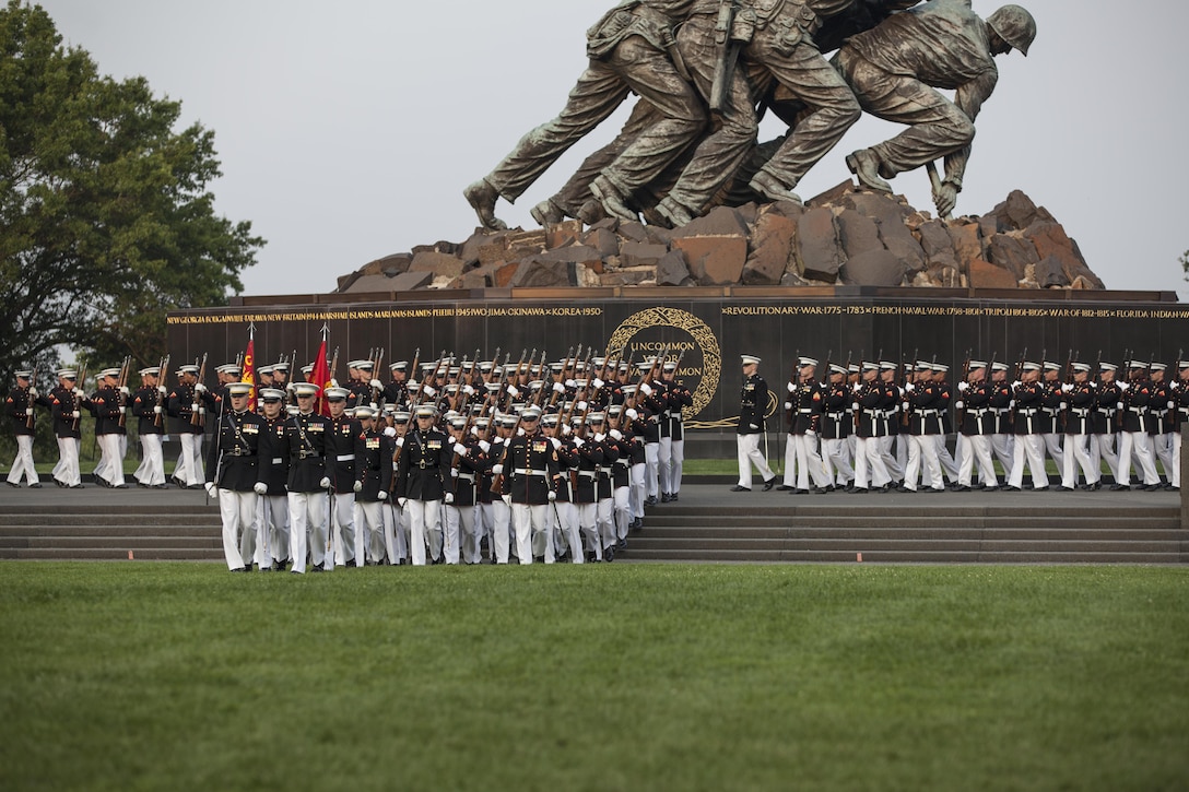 U.S. Marines with Marine Barracks Washington, D.C. march in front of the Marine Corps War Memorial, Arlington, Va., July 7, 2015. Retired Marine Corps Chief Warrant Officer 4 Hershel “Woody” Williams was the guest of honor for the parade, and Lt. Gen. Ronald L. Bailey, deputy commandant of Plans, Policies, and Operations, was the hosting official. Since September 1956, marching and musical units from Marine Barracks Washington, D.C., have been paying tribute to those whose“uncommon valor was a common virtue” by presenting sunset parades in the shadow of the 32-foot high figures of the United States Marine Corps War Memorial. (U.S. Marine Corps photo by Lance Cpl. Samantha K. Draughon/ Released)
