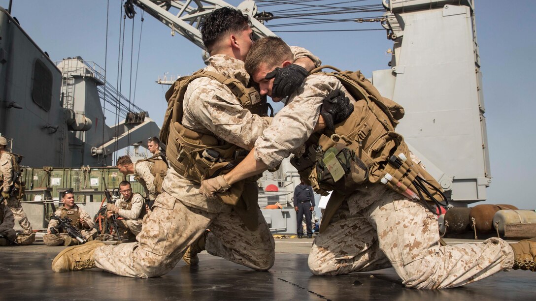 Lance Cpl. Paul Kainz, left, grapples Lance Cpl. Christian Calderella during a short-range marksmanship qualification course aboard the dock landing ship USS Rushmore (LSD 47). Marines grappled for two minutes prior to going through the course of fire to simulate firing under stress and fatigue, which can occur in combat. Kainz and Calderella are both automatic riflemen with Company K, Battalion Landing Team 3rd Battalion, 1st Marine Regiment, 15th Marine Expeditionary Unit. 