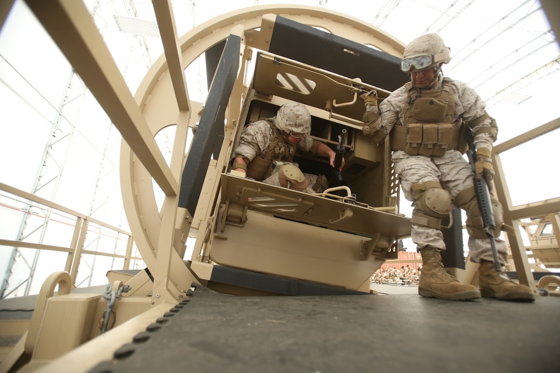 Sgt. Christopher R. Ramos, a motor vehicle operator with the 13th Marine Expeditionary Unit, holds the rear doors of a simulated overturned vehicle open for another Marine during HMMV Egress Assistance Training aboard Marine Corps Base Camp Pendleton, Calif., June 30, 2015. The cooperation between these two Marines is a small example of the unit cohesion that is fostered in preparation for deployment. (U.S. Marine Corps photo by Lance Cpl. Alvin Pujols/Released)
