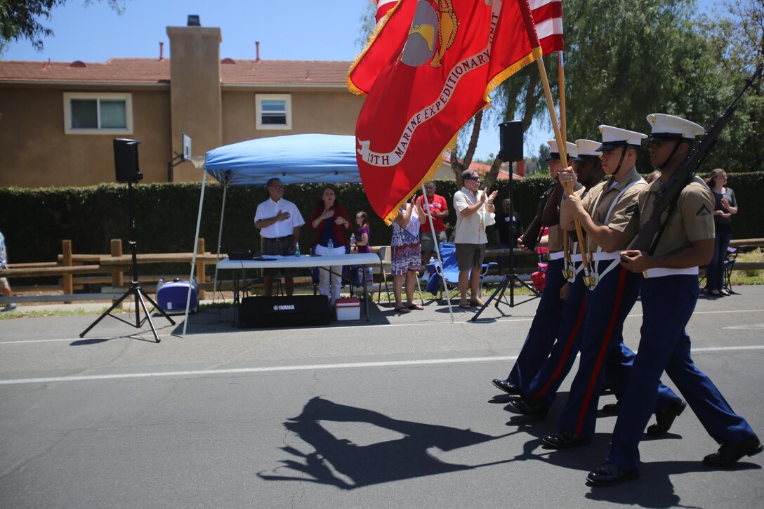 Marines from the 13th Marine Expeditionary Unit march alongside their adopted families in the city of Anaheim, Calif., July 4th, 2015. The Anaheim Marine Adoption Committee adopted the 13th MEU and provides aid in the form of baby baskets, care packages and homes to take refuge for the Marines who aren't able to return hom for the holidays.(U.S. Marine Corps photo by Lance Cpl. Alvin Pujols/Released)