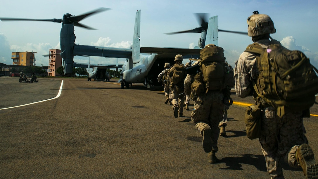 A squad of U.S. Marines with Special-Purpose Marine Air-Ground Task Force Crisis Response-Africa rush onto an MV-22B Osprey in Accra, Ghana, March 27, 2015. The Marines conducted combat loading and offloading drills designed to hone their ability to rapidly embark on the aircraft and secure a landing zone. 