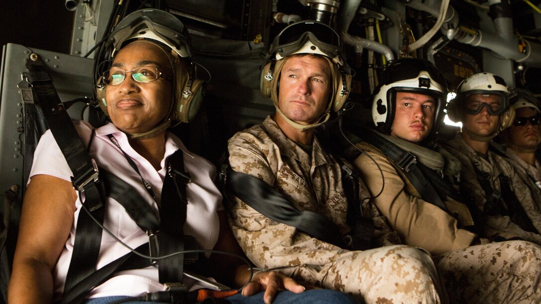 Cynthia Akuetteh, left, U.S. Ambassador to the Republic of Gabon, looks out the back of an MV-22 Osprey, with Special-Purpose Marine Air-Ground Task Force Crisis Response-Africa's commanding officer, Col. Thomas Savage. The Osprey flew over a Cooperative Security Location established by SPMAGTF-CR-AF in Libreville, Gabon, June 23, 2015. U.S. Marines accompanied French and Gabonese personnel to a training site, where service members from the three nations completed training together. 