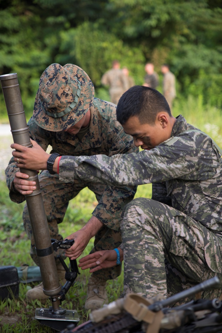 Cpl. Juan J. Rodriguez (left), a mortar section leader with Company G, 2nd Battalion, 24th Marine Regiment, shows Gunnery Sgt. Chaeho Lee, a platoon sergeant with 6th Company, 2nd Battalion, 7th Regiment, ROK Marines, the capabilities of the M224 mortar in Pohang, Republic of Korea, July 4, 2015. Peninsula Express is the eighth iteration this year of the Korean-Marine Exchange Program and the first time Marine Forces Reserve has participated in the  series of exercises between the U.S. and Republic of Korea Marine Corps designed to build interoperability and tactical familiarity between partner nations. 