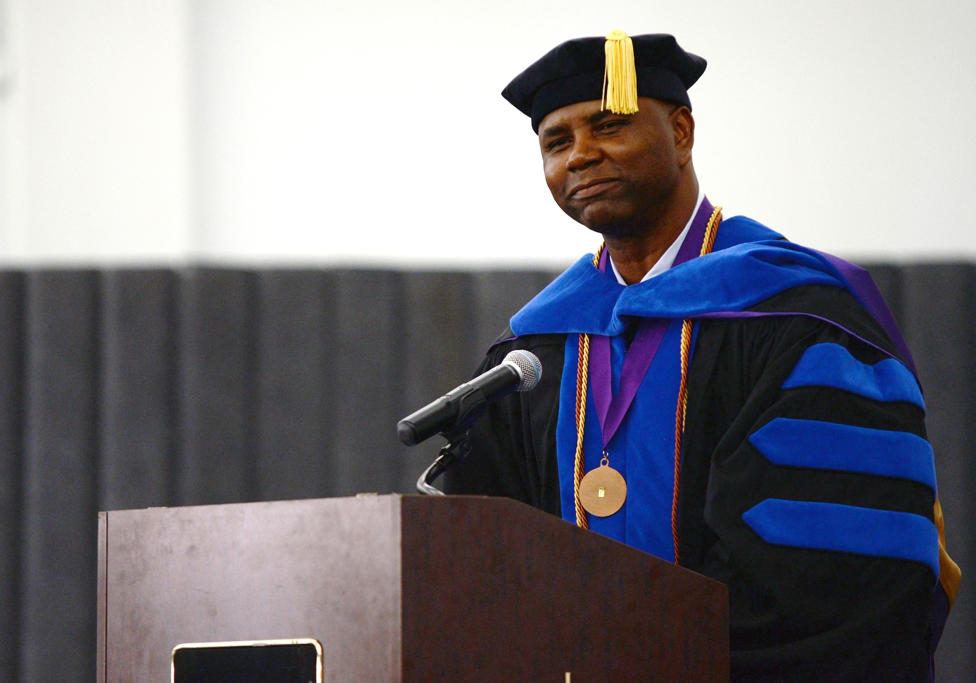 U.S. Air Force Chief Master Sgt. Marvin Parker, 36th Mission Support Group superintendent, shares anecdotes from his educational journey during a Community College of the Air Force graduation ceremony June 26, 2015, at Andersen Air Force Base, Guam. Parker holds a doctorate in business administration, summa cum laude, and wore his academic regalia to inspire other Airmen to continue their academic journey beyond a two-year degree. (U.S. Air Force photo by Senior Airman Alexander W. Riedel/Released)