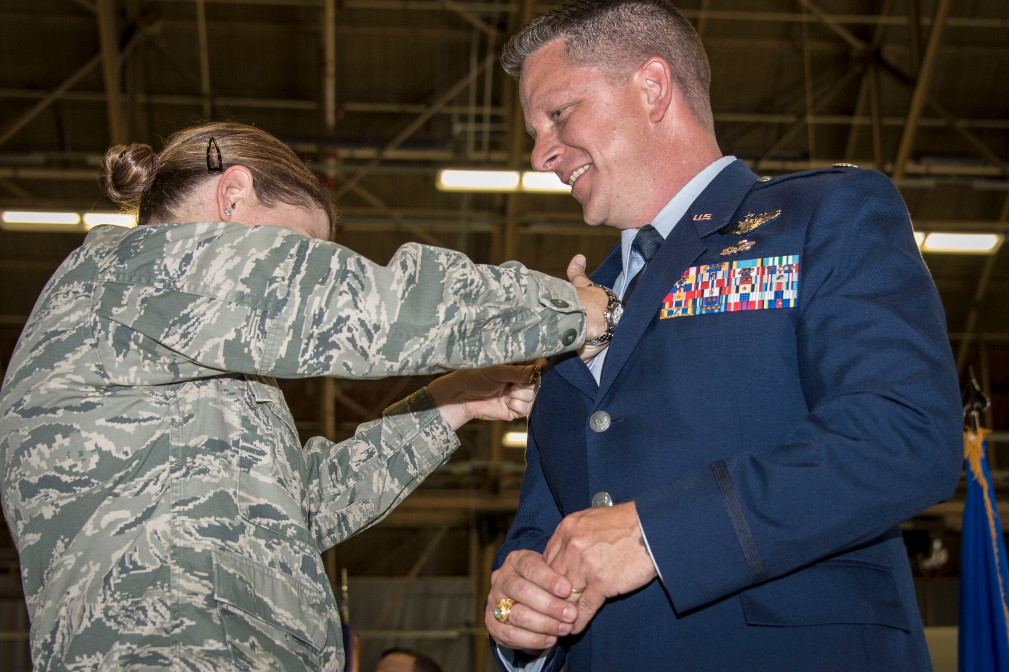 Lt. Col. Carolyn Coleman, 92nd Mission Support Group deputy commander, pins the command badge on her husband, Lt. Col. Matthew Coleman, 92nd Operations Support Squadron commander, during the 92nd OSS change of command ceremony July 9, 2015, at Fairchild Air Force Base, Wash. Coleman promotes within Team Fairchild from his previous command as the 92nd Air Refueling Wing chief of safety. (U.S. Air Force photo/Staff Sgt. Benjamin W. Stratton)