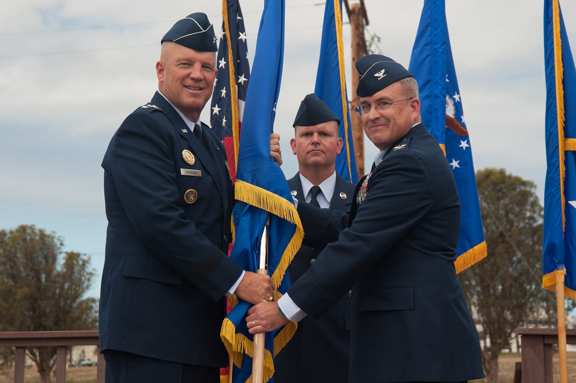 Lt. Gen. John W. “Jay” Raymond, commander, 14th Air Force (Air Forces Strategic) and Joint Functional Component Command for Space, presents the 30th Space Wing guidon flag to the incoming 30th SW commander, Col. J. Christopher Moss, during a change of command ceremony, July 9, 2015, Vandenberg Air Force Base, Calif. (U.S. Air Force photo by Michael Peterson/Released)
