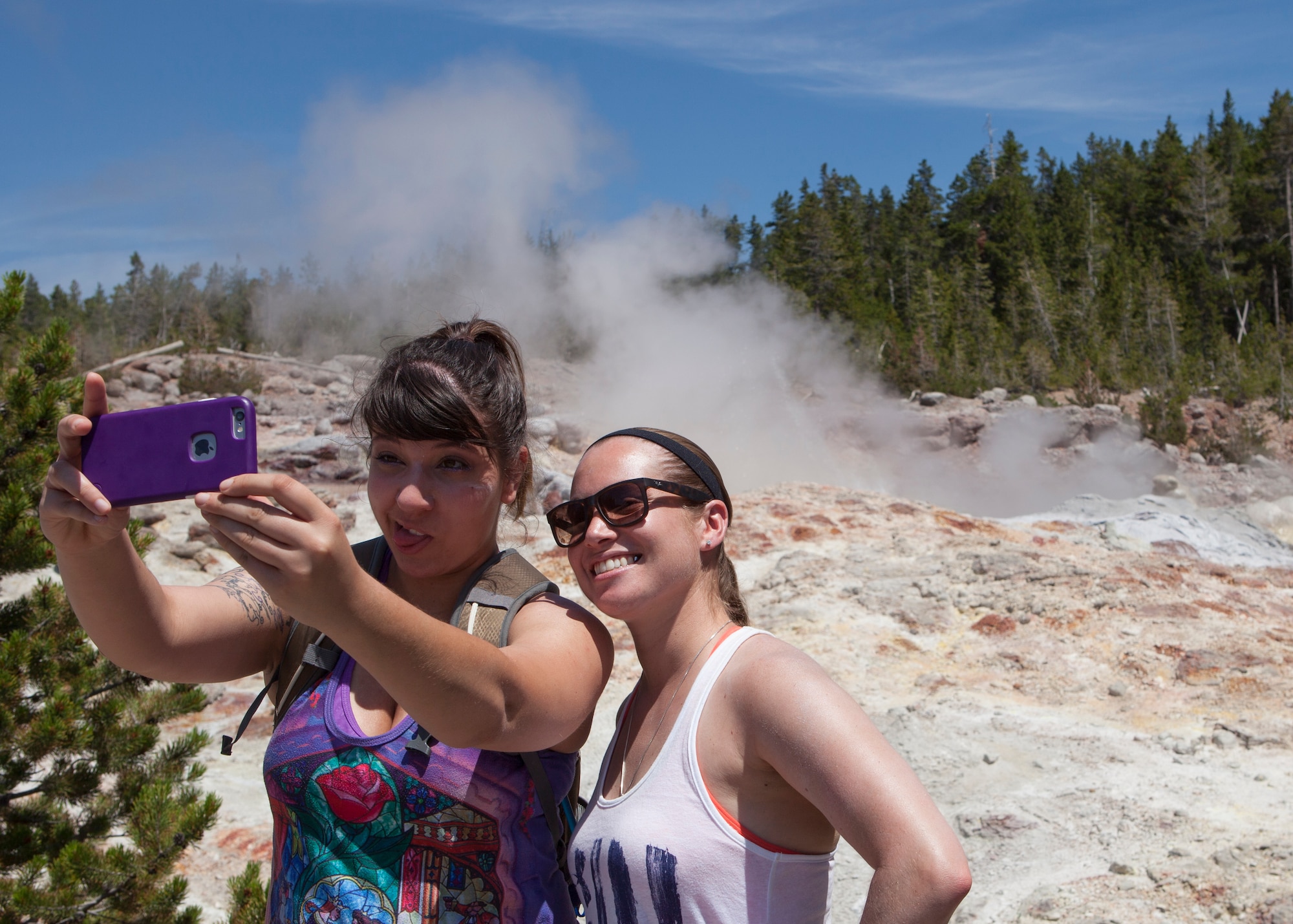 Senior Airman Marina Martinez and Rachel Silverberg, 90th Force Support Squadron, take a selfie with a geyser in the background in Yellowstone National Park, Wyo., July 4, 2015. Martinez and Silverberg were participants of an F.E. Warren Air Force Base Outdoor Recreation trip exploring Yellowstone and Grand Teton National Park for the July 4th weekend. (U.S. Air Force photo by Lan Kim)
