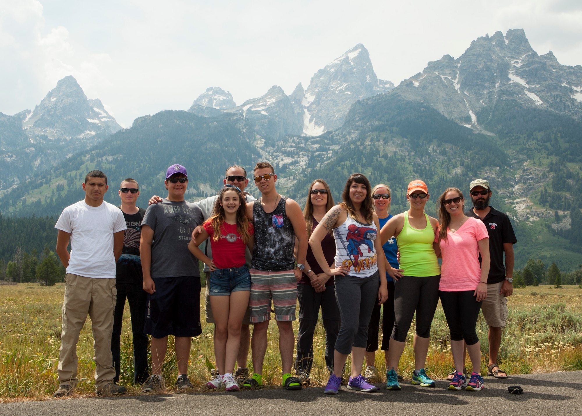 Trip participants of an F.E. Warren Air Force Base Outdoor Recreation trip pose for a group photo with the Teton Range in the background in Grand Teton National Park, Wyo., July 3, 2015. Outdoor Recreation hosted a trip to Grand Teton and Yellowstone National Park for the July 4th weekend which included camping, hiking and sightseeing the natural attractions of the parks. (U.S. Air Force photo by Lan Kim)