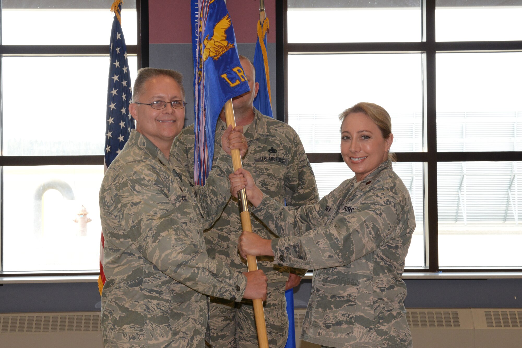 U.S. Air Force Col. Richard Cole, the 354th Mission Support Group commander, passes the 354th Logistics Readiness Squadron guidon to Maj. Marie Meihls, the new 354th LRS commander, July 9, 2015, at Eielson Air Force Base, Alaska. Meihls previously commanded the 422nd Supply Chain Management Squadron, Tinker AFB, Okla. (U.S. Air Force photo by Senior Airman Ashley Nicole Taylor/Released)