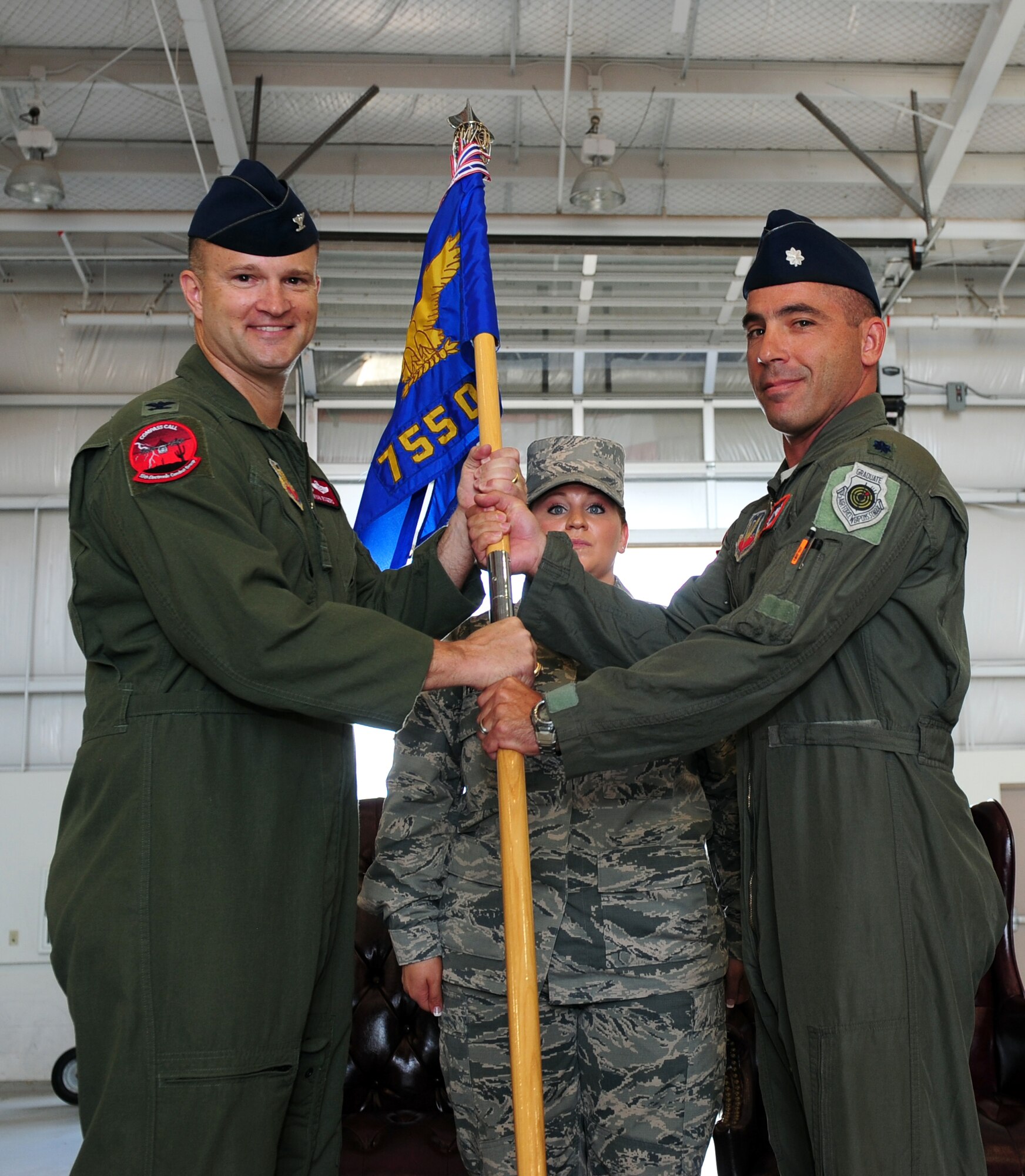 U.S. Air Force Col. Ryan Rogers, 55th Electronic Group commander, passes the 755th Operations Support Squadron's guidon to Lt. Col. Joshua Koslov, 755th OSS commander, during a change of command ceremony at Davis-Monthan Air Force Base, Ariz., July 9, 2015. The commander is responsible for group support functions such as intelligence, current operations, plans and exercises, weapons and tactics, and operational support. (U.S. Air Force photo by Airman 1st Class Chris Drzazgowski/Released) 